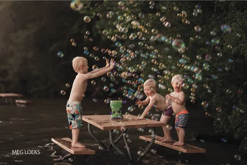 servizi fotografici bambini giocano con bolle di sapone all'aperto
