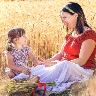 Servizi Fotografici Mommy Me Reggio Emilia mamma e figlia si guardano e sorridono in un campo di grano maturo