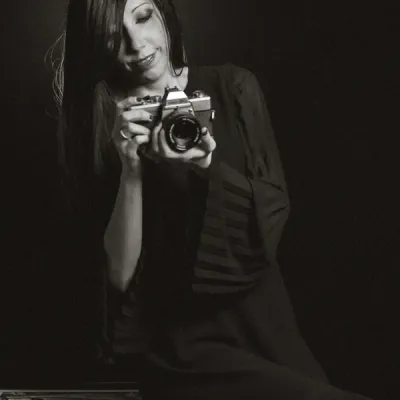 Servizi Fotografici Ritratto In Studio Reggio Emilia fotografia in bianco e nero di una ragazza che scatta una foto con la sua fotocamera vintage